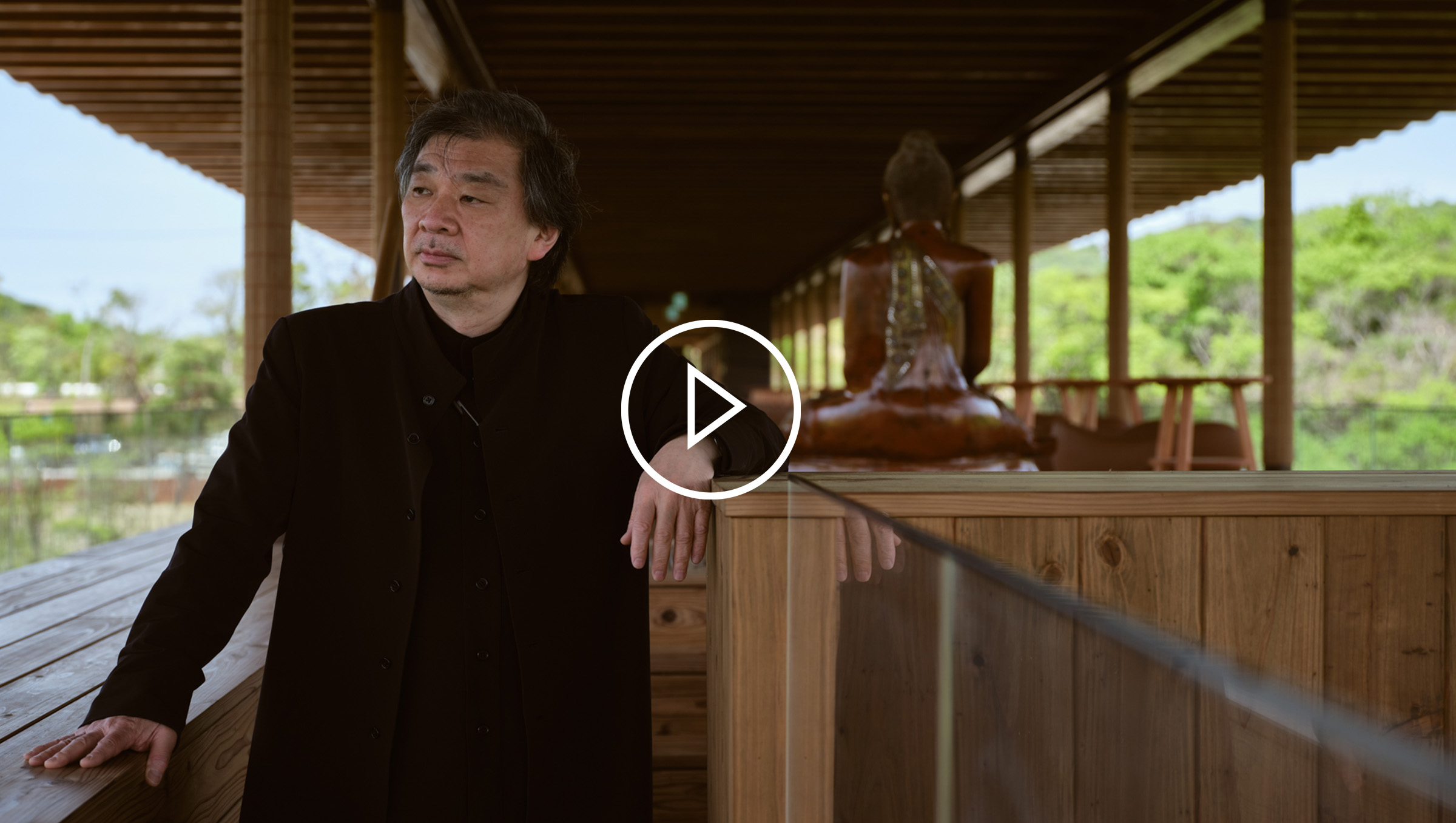 Japanese architect, Shigeru Ban standing on his Zen Wellness Seinei building in Hyogo.