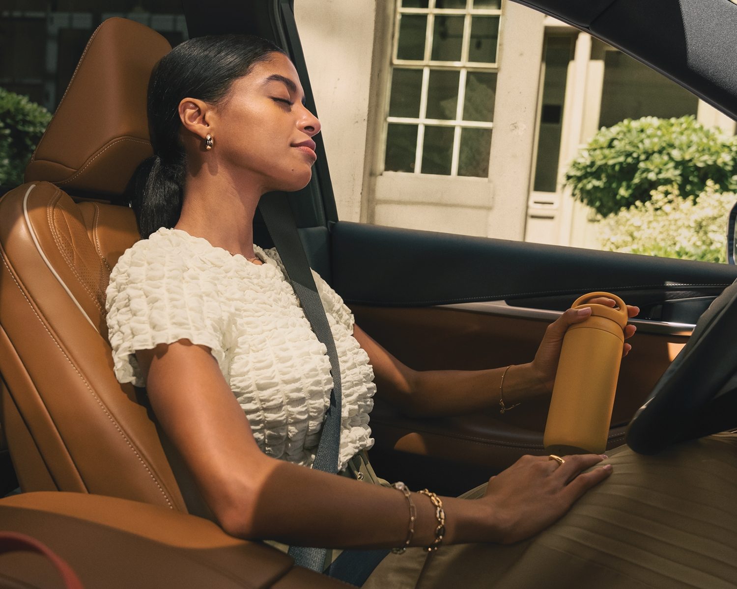 Vehicle interior featuring woman enjoying INFINITI signature scent inspired by Japanese cypress and citrus