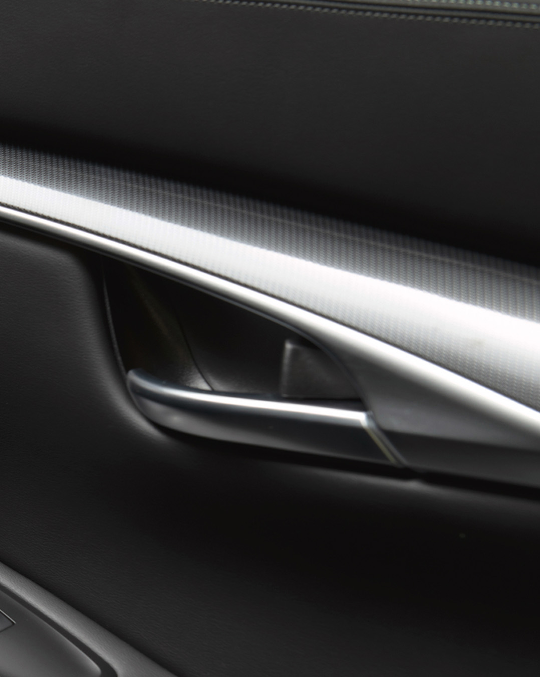 Interior door detail of 2025 INFINITI QX50 featuring Japanese craft-inspired black aluminum