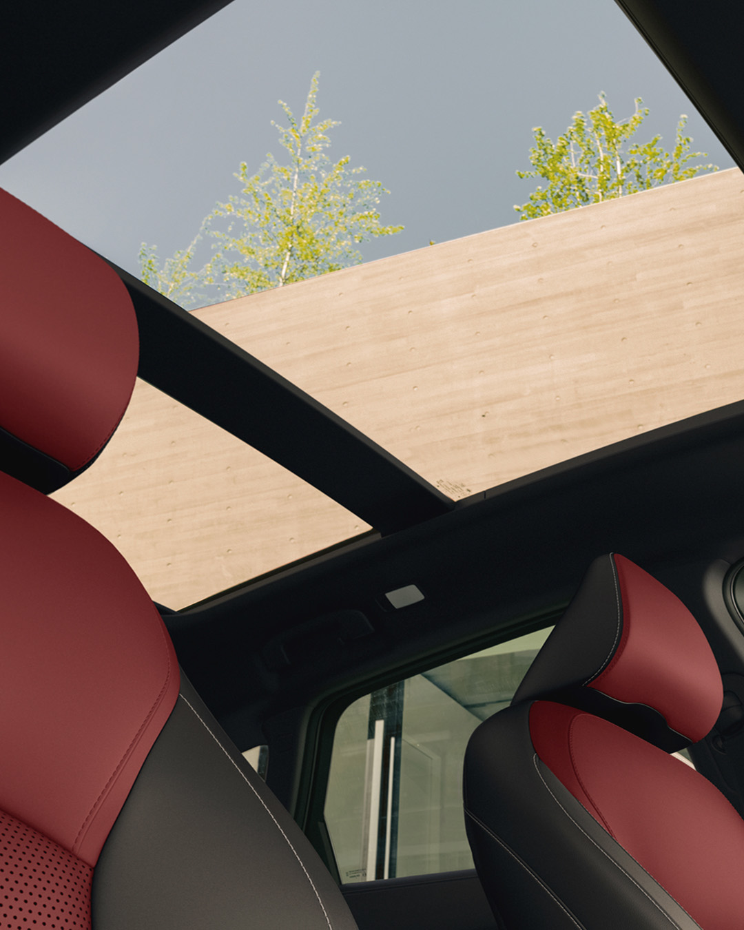 Panoramic moonroof of 2025 INFINITI QX50 letting in natural light over red leather seats