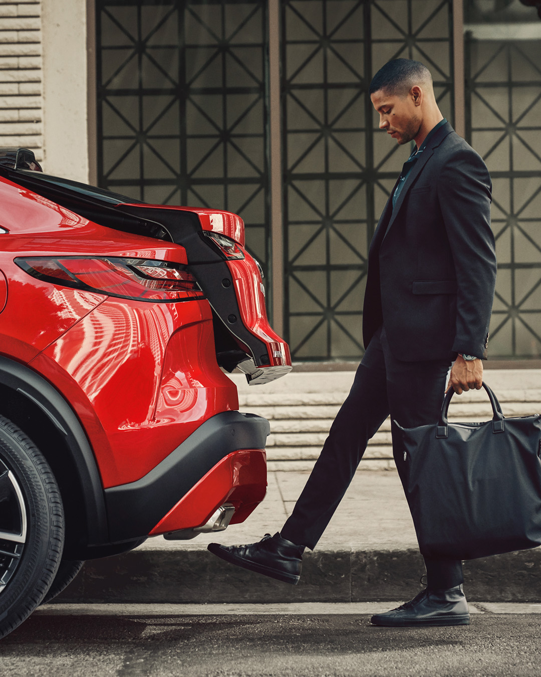 Man activating the motion-activated rear liftgate on the QX55 with a foot swipe