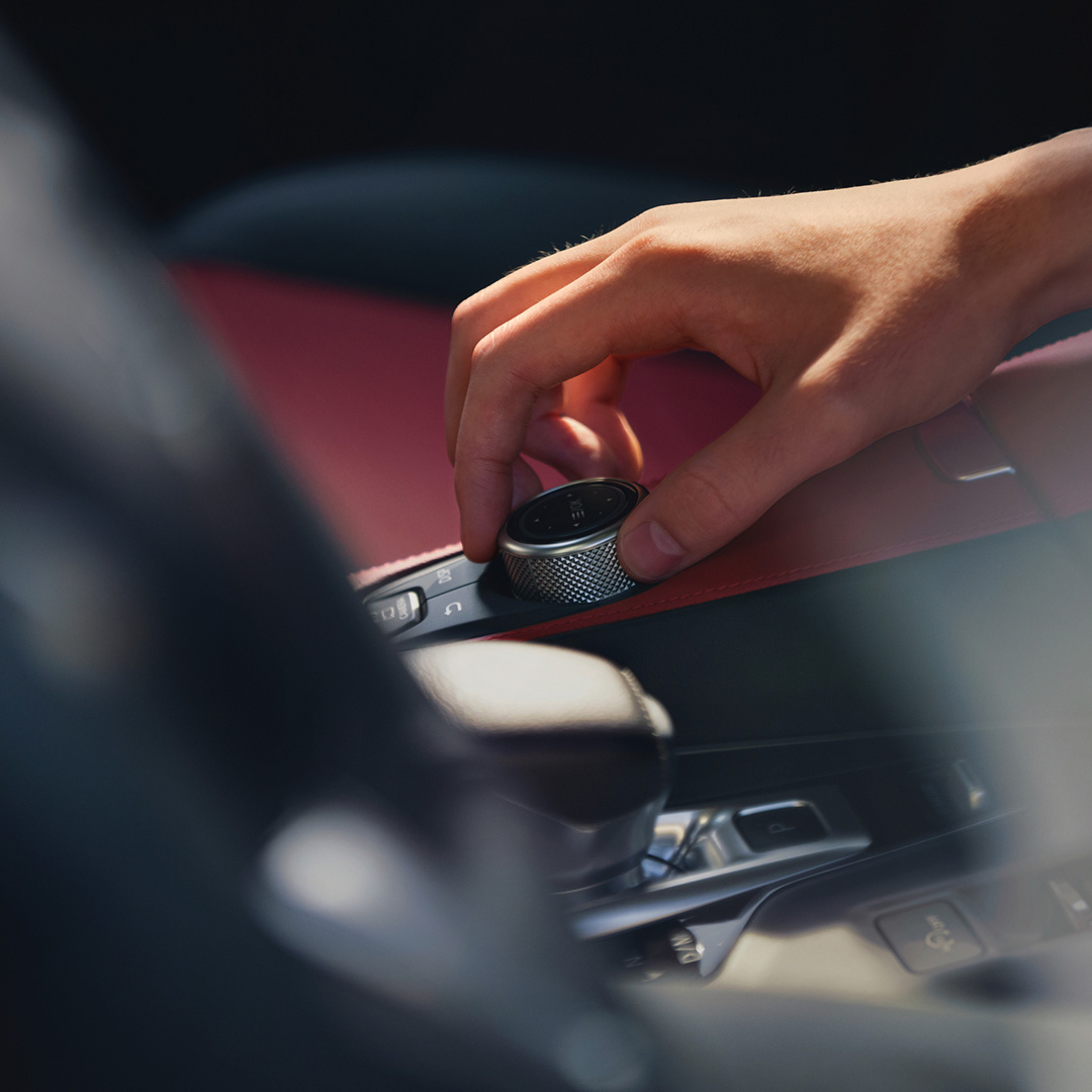Close-up of drive mode dial with Monaco Red interior color in the QX55