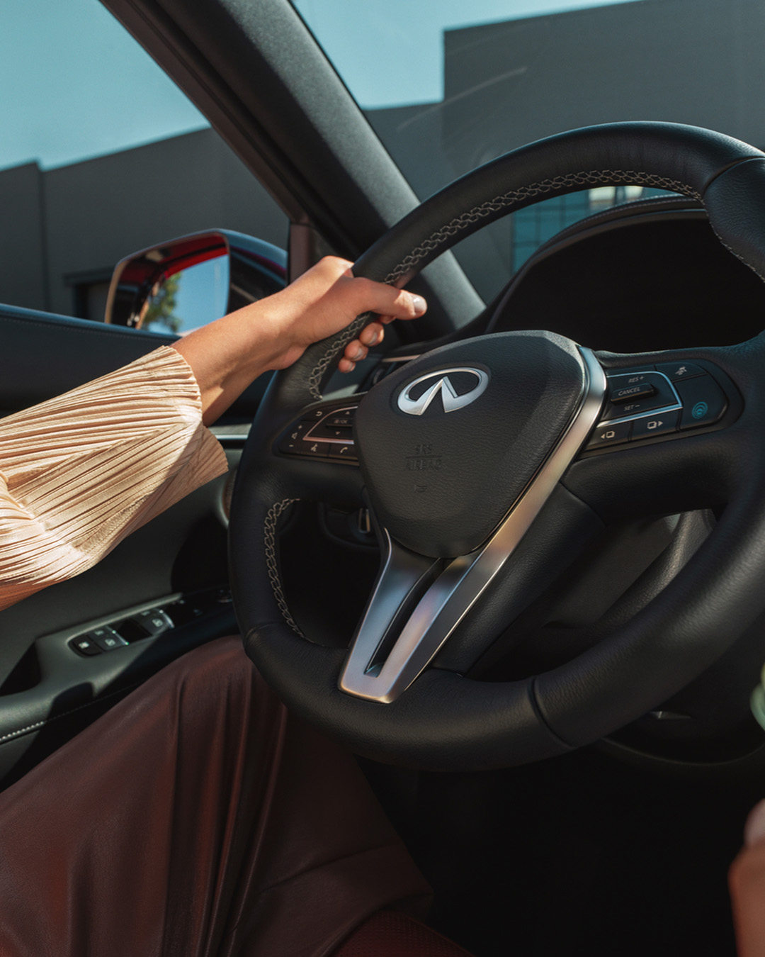 Close-up of leather-wrapped steering wheel in the QX55