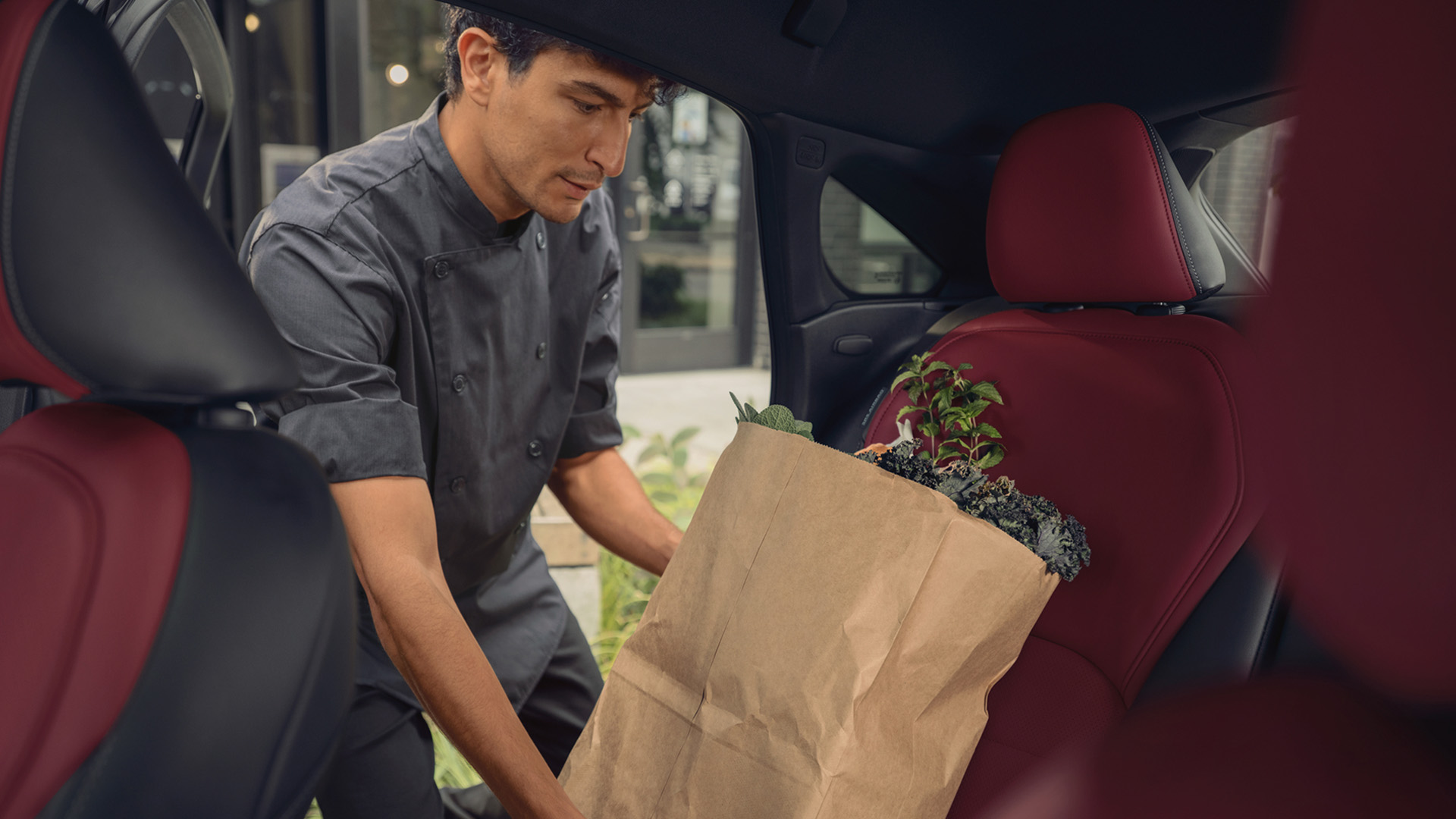 Man placing grocery bag into the spacious rear seat of the QX55