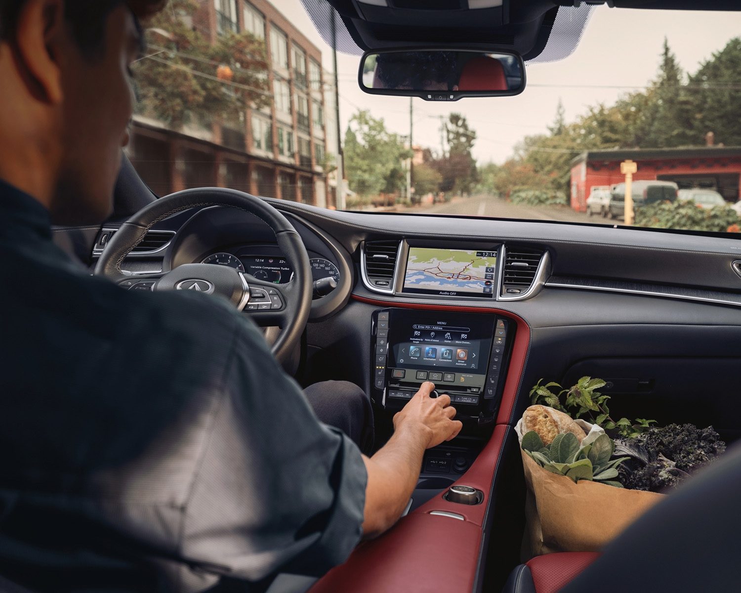 Man driving QX55 with dual touchscreen visible