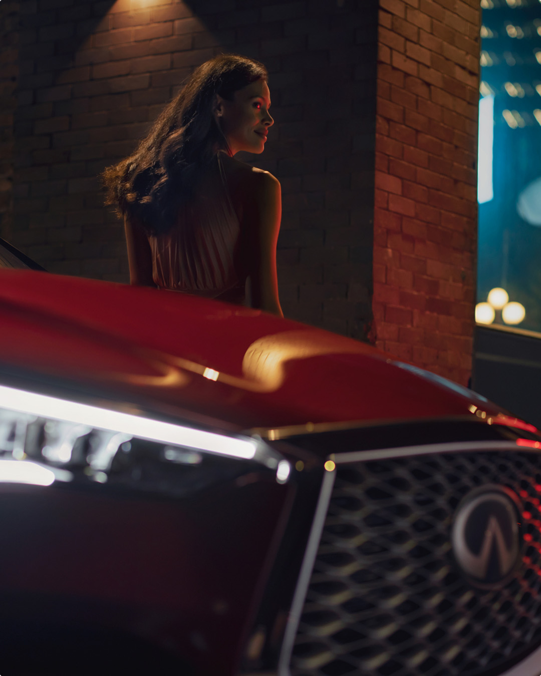Closeup of woman leaning against QX55 showcasing sport-style grille