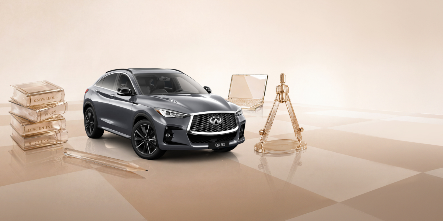 Angled view of a white 2024 INFINITI Q50 Luxury Sport Sedan driving fast