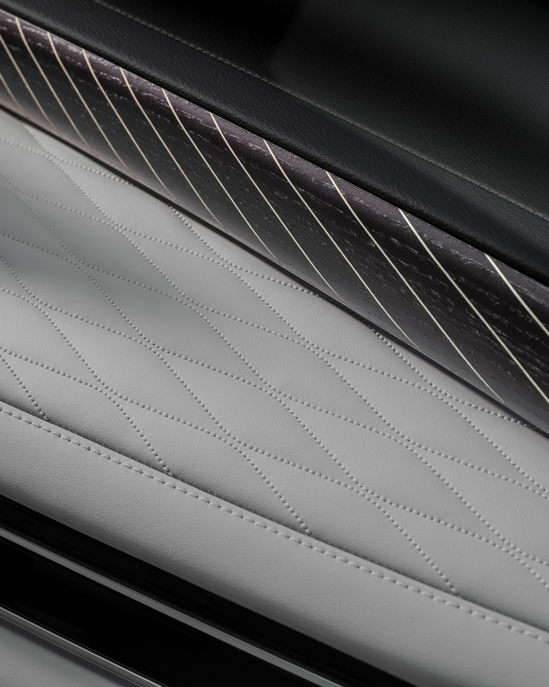 Close-up of soft leather upholstery with contrast stitching and open-pore wood trim