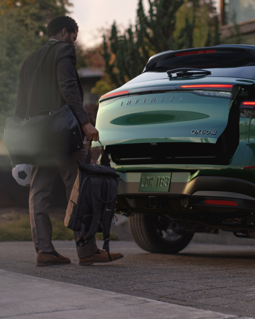 Motion-activated liftgate on 2026 INFINITI QX60 opening while driver approaches with gear