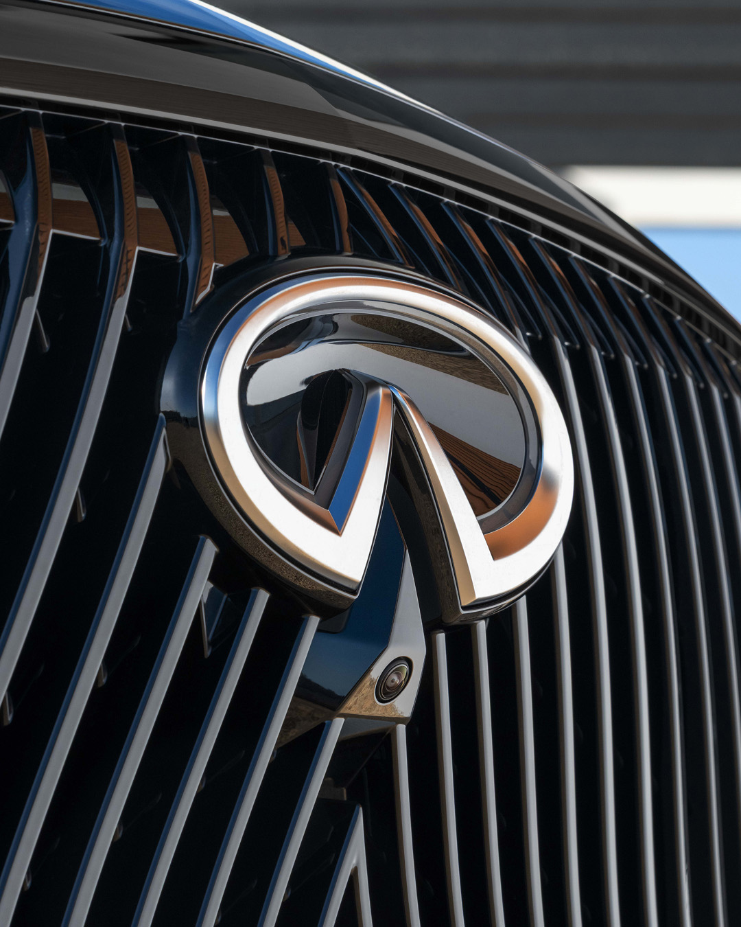 Close-up of the new illuminated INFINITI logo on black grille of the 2026 QX60