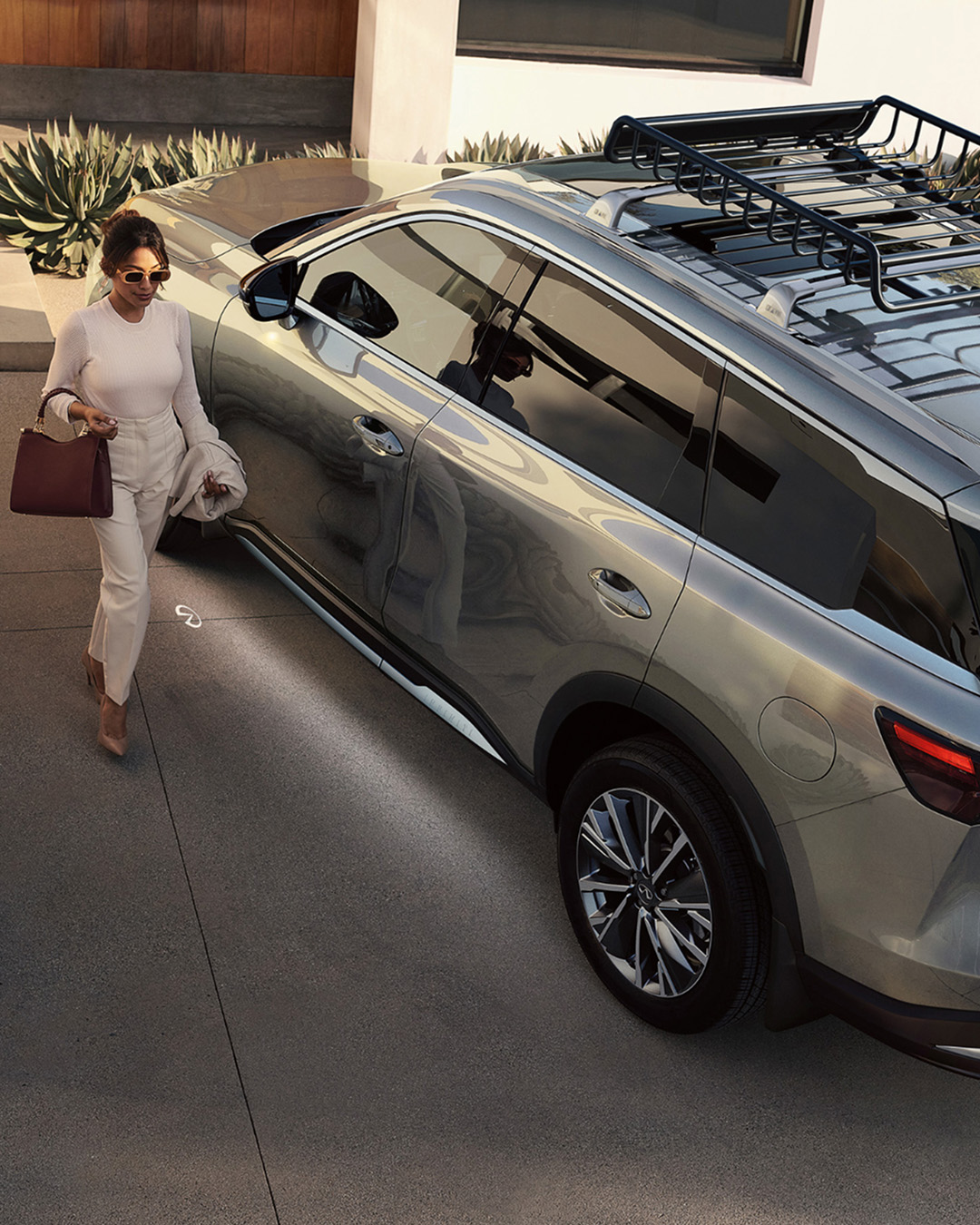 Overhead view of a woman approaching QX60 with Intelligent Key, welcome lighting activated