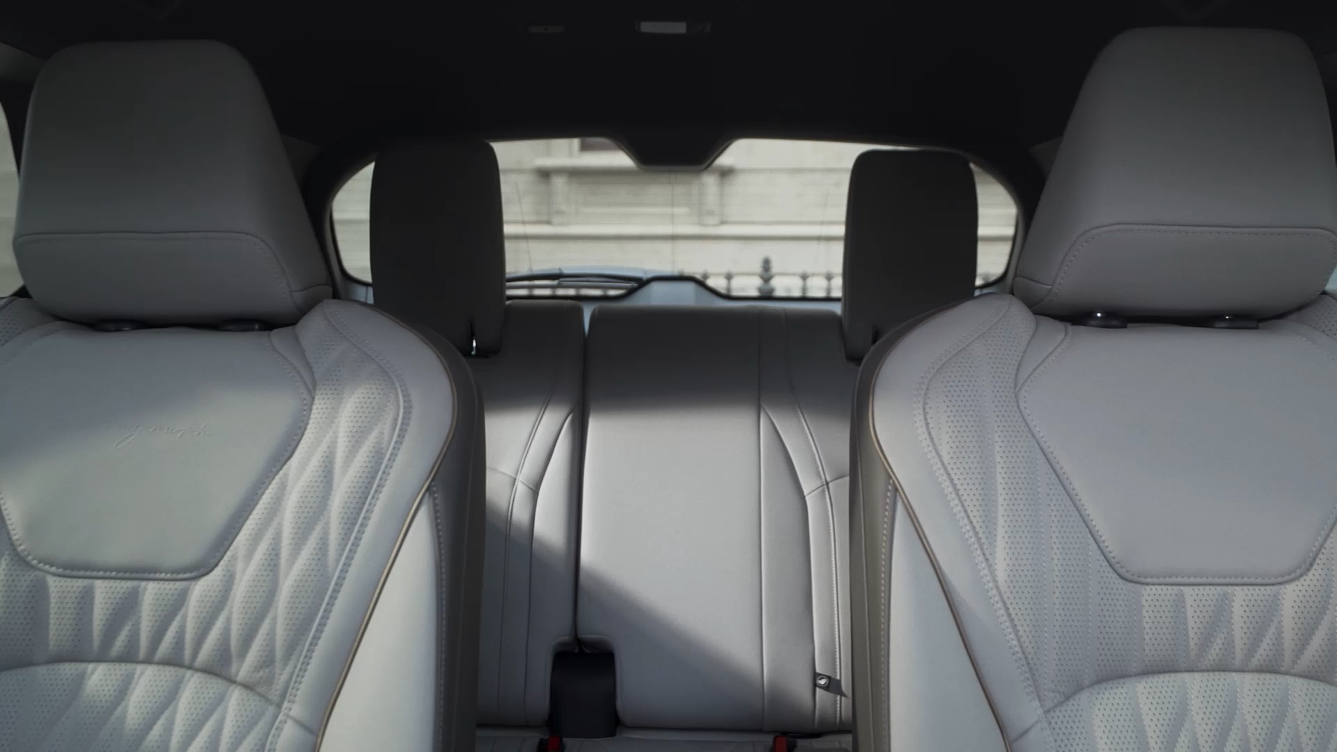 Rear interior of 2026 INFINITI QX60 showing all three seating rows, promoting 7-passenger capacity