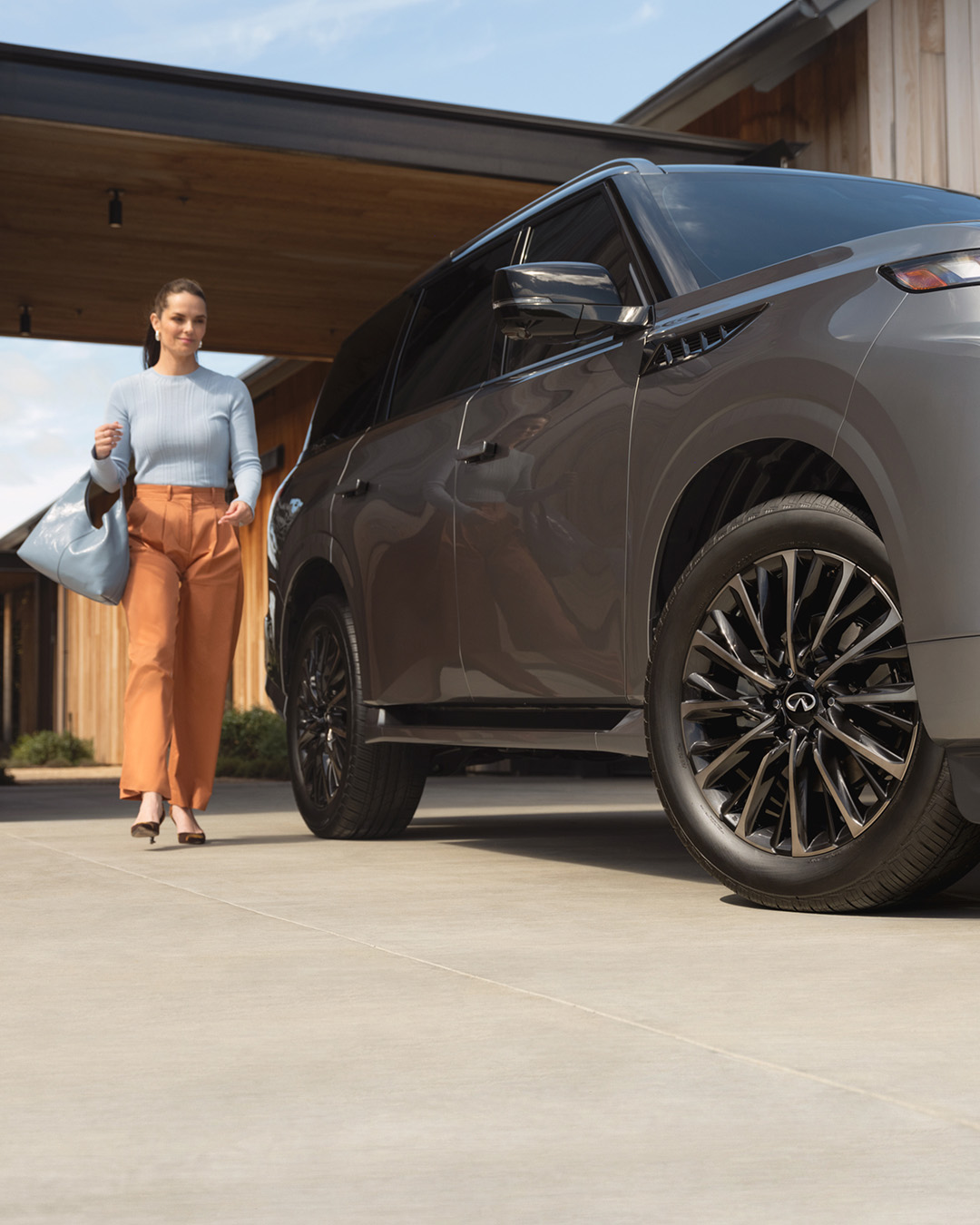 INFINITI owner walking toward QX60 in driveway