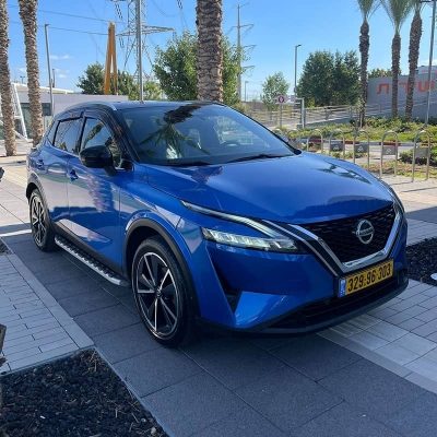 מבט מלפנים בזווית ימינה על מכונית ניסאן קשקאי בצבע כחול מטאלי וגג שחור