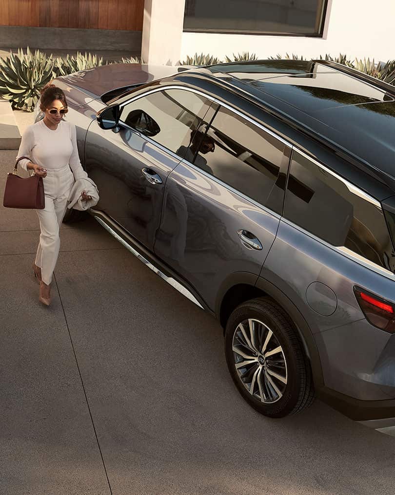 אישה מתקרבת לרכב INFINITI QX60 ומשתמשת בהתנעה מרחוק