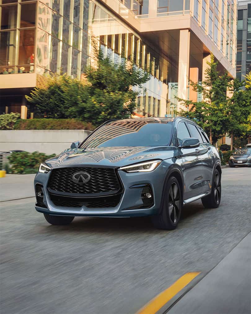 מבט מלפנים על מכונית אינפיניטי QX50 חונה לצד בניין משרדים