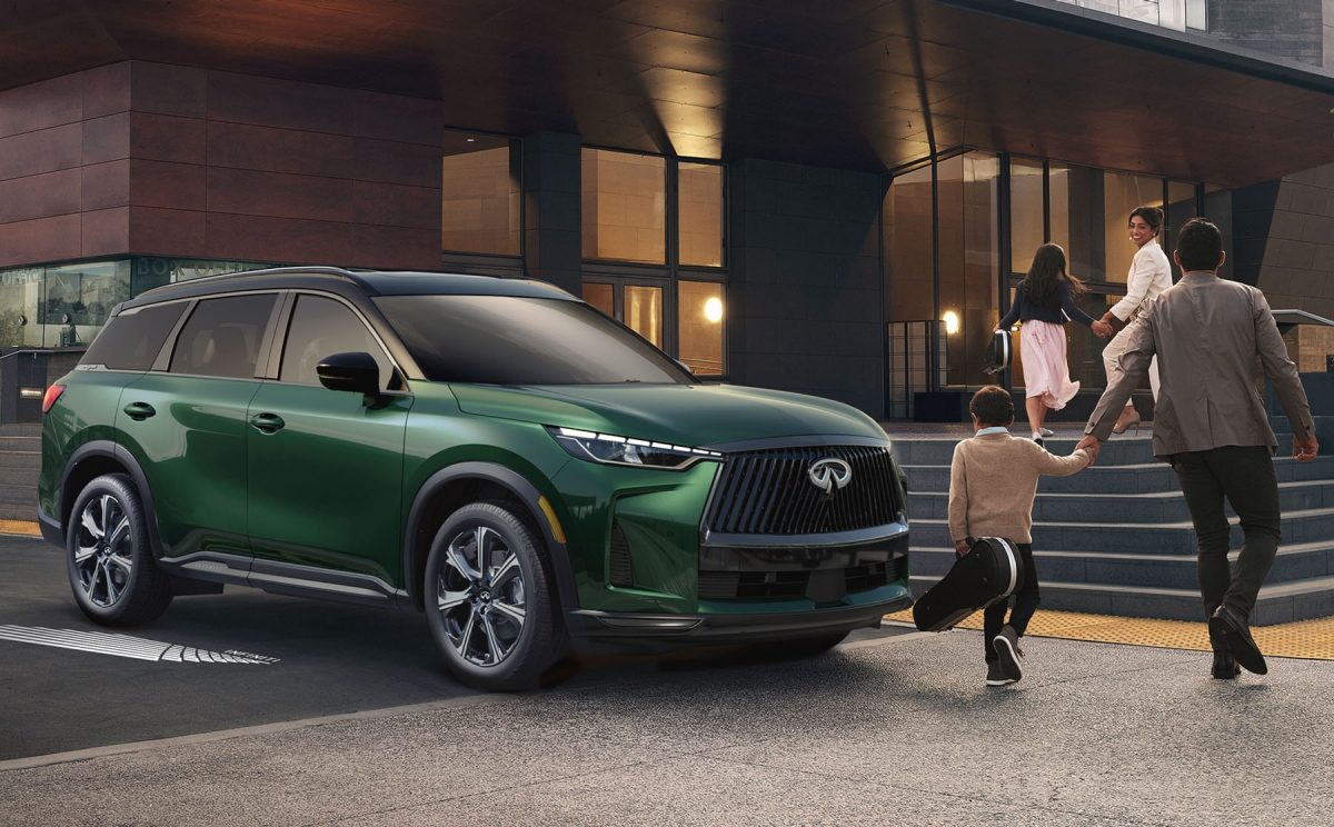INFINITI QX60 in green parked outside of theatre as family walks in