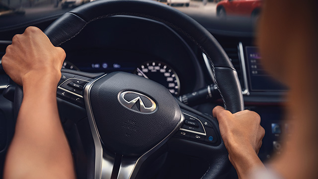 Driver using Direct Adaptive Steering in an INFINITI car, ensuring smooth and precise handling
