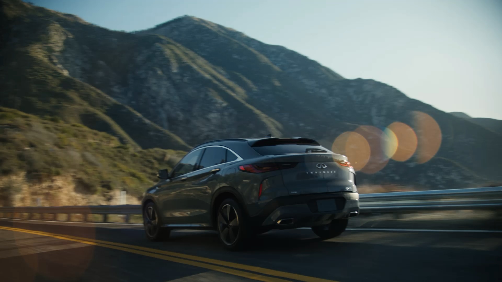 INFINITI car with Variable Compression Turbo driving through scenic mountain roads, showcasing power and performance