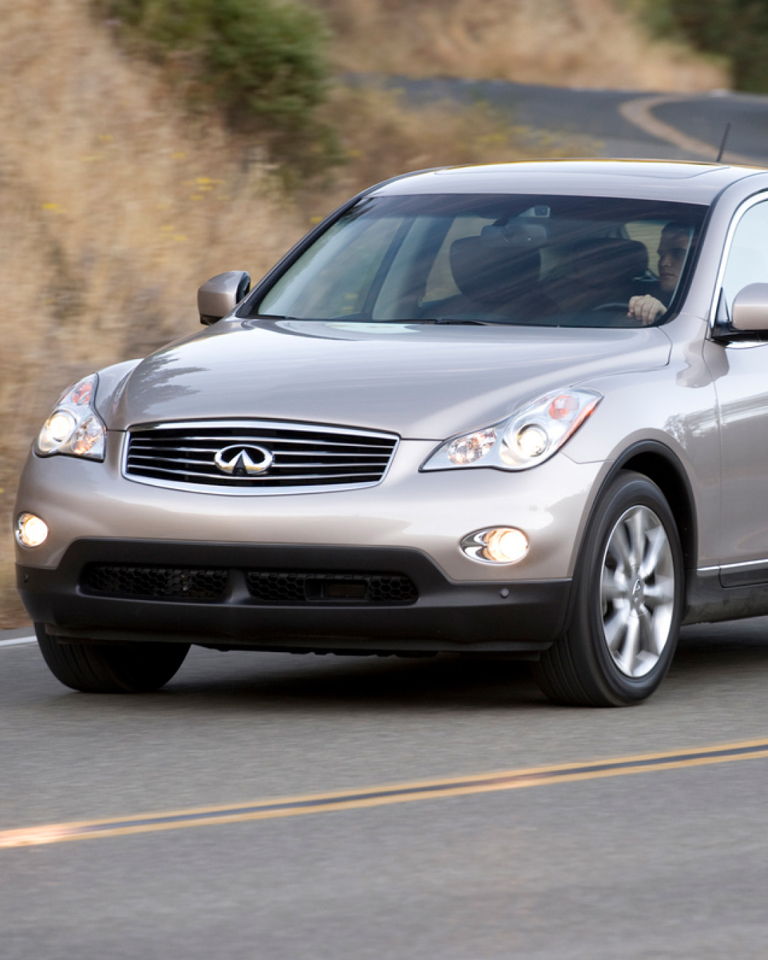 INFINITI EX35 Luxury compact SUV driving past grassy hill