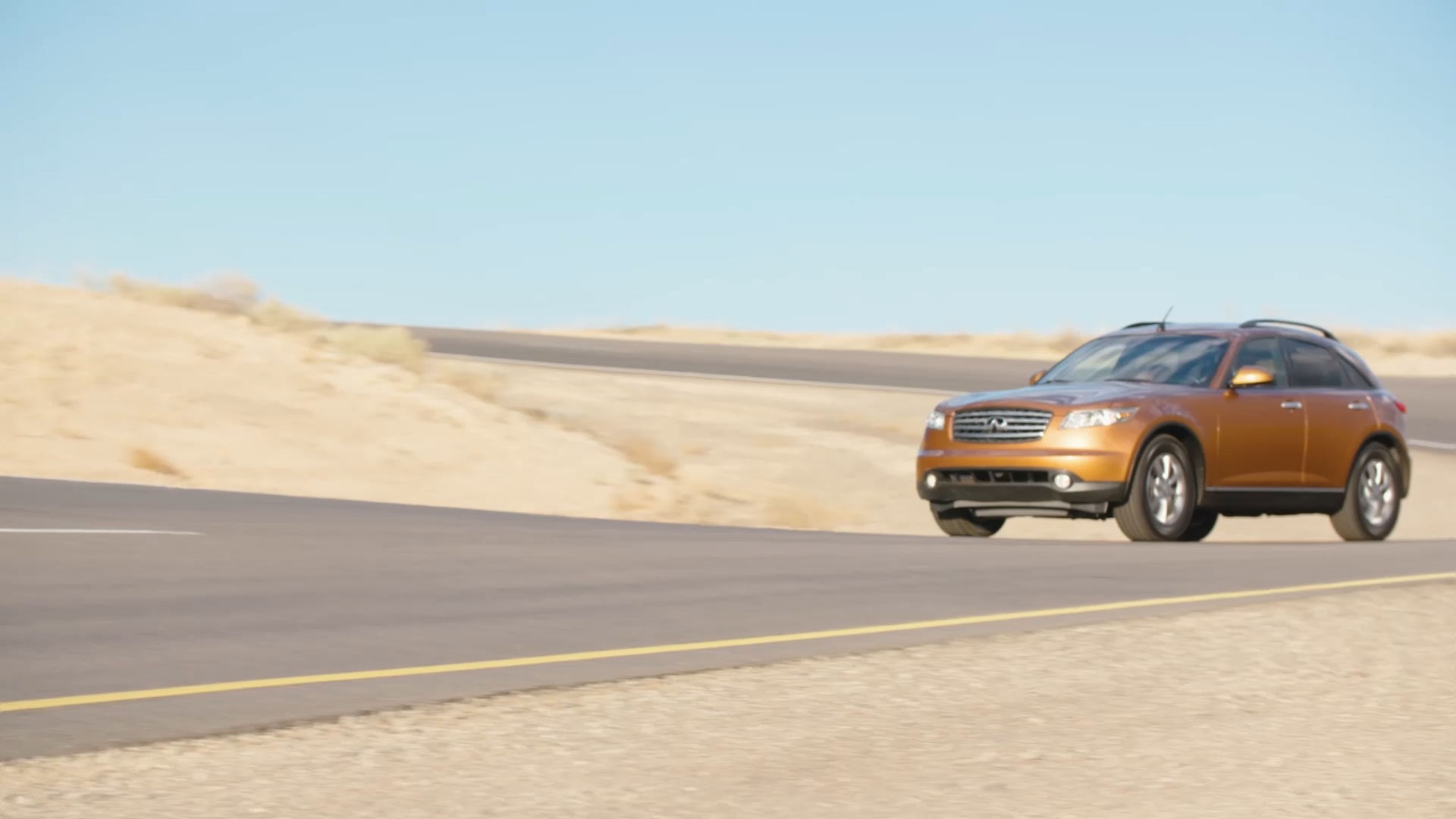 INFINITI FX35 luxury crossover coupe driving past sandy terrain