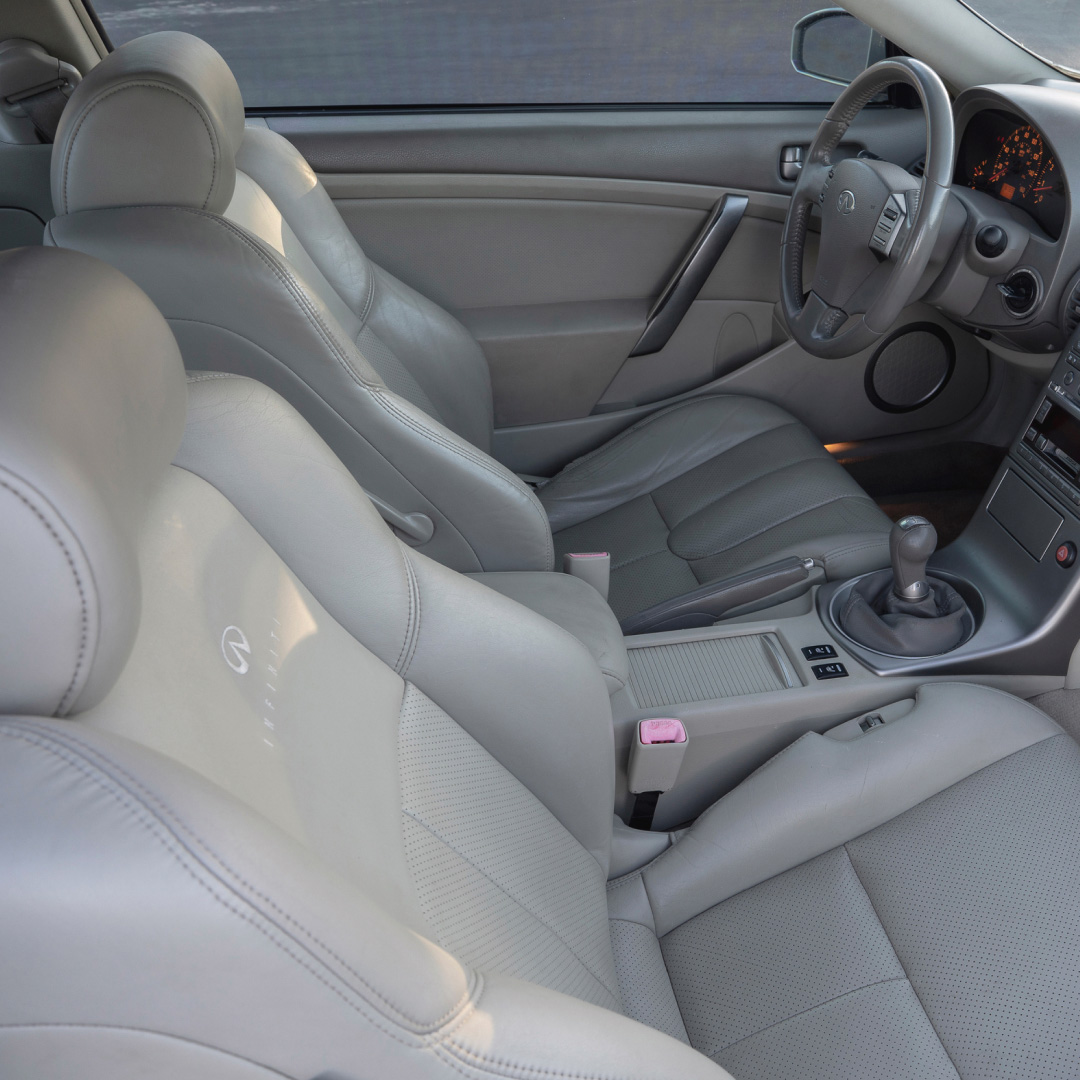 Interior view of the INFINITI G35 luxury sport coupe driver's seat and steering wheel