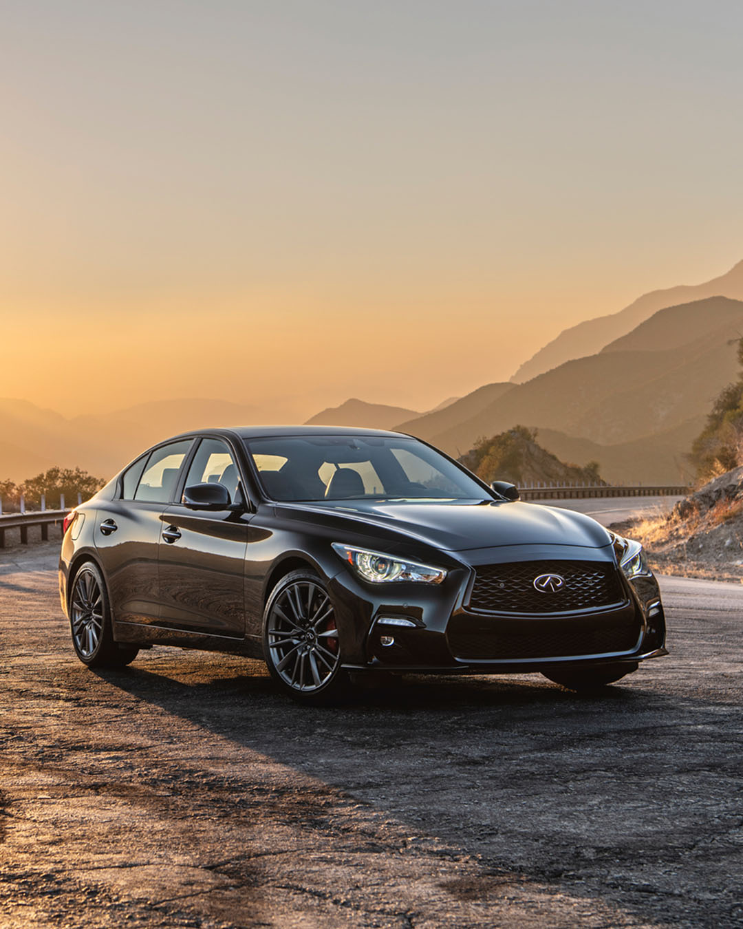 INFINITI Q50 parked on mountain road at sunset