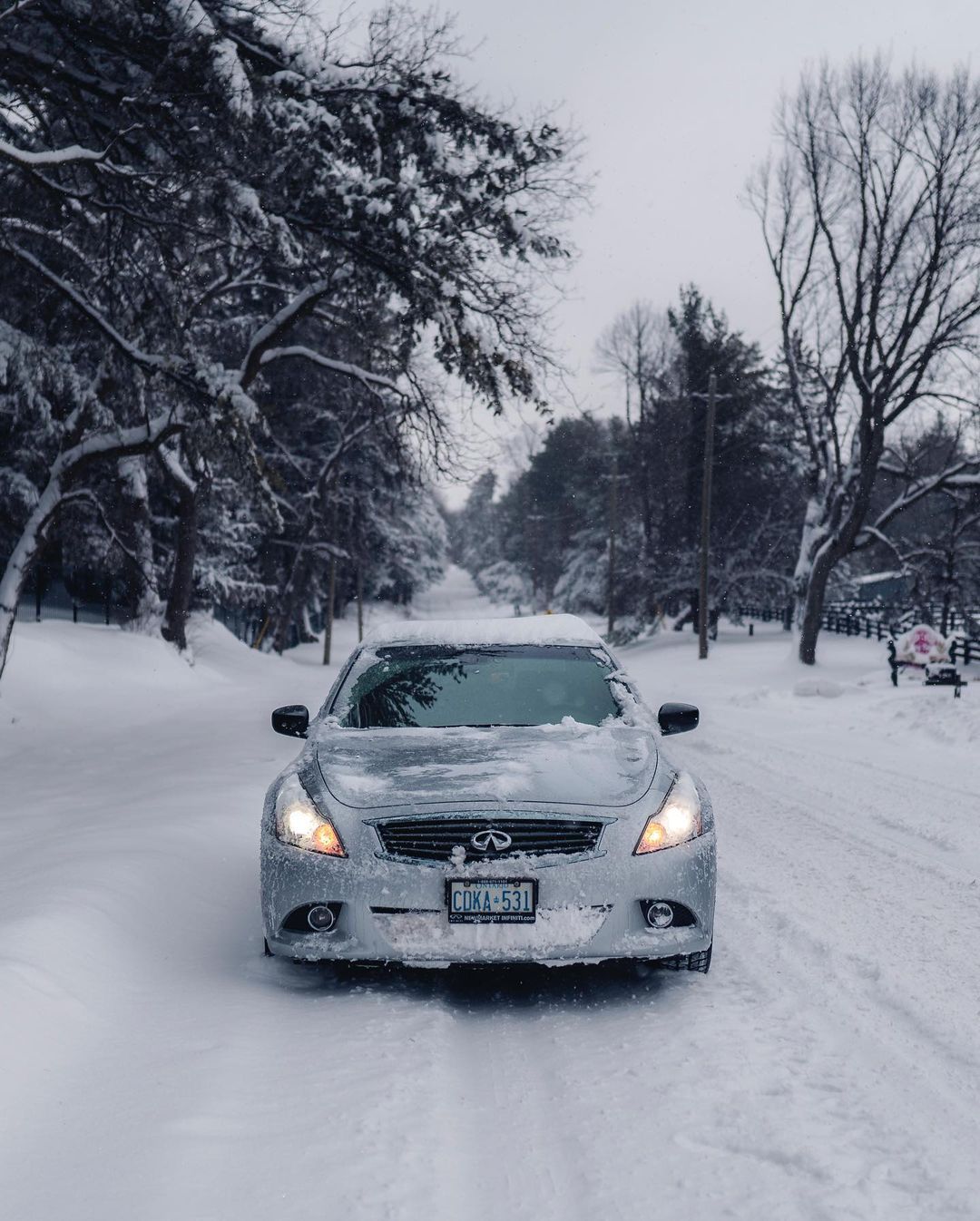 Front view of INFINITI G37 luxury sport coupe driving through snow