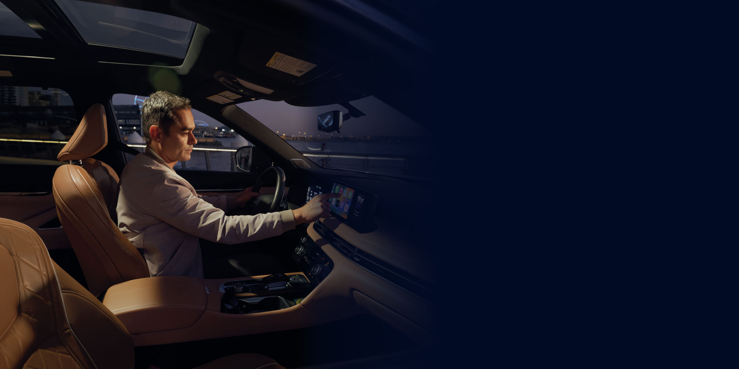 Driver in the INFINITI SUV using the touchscreen system