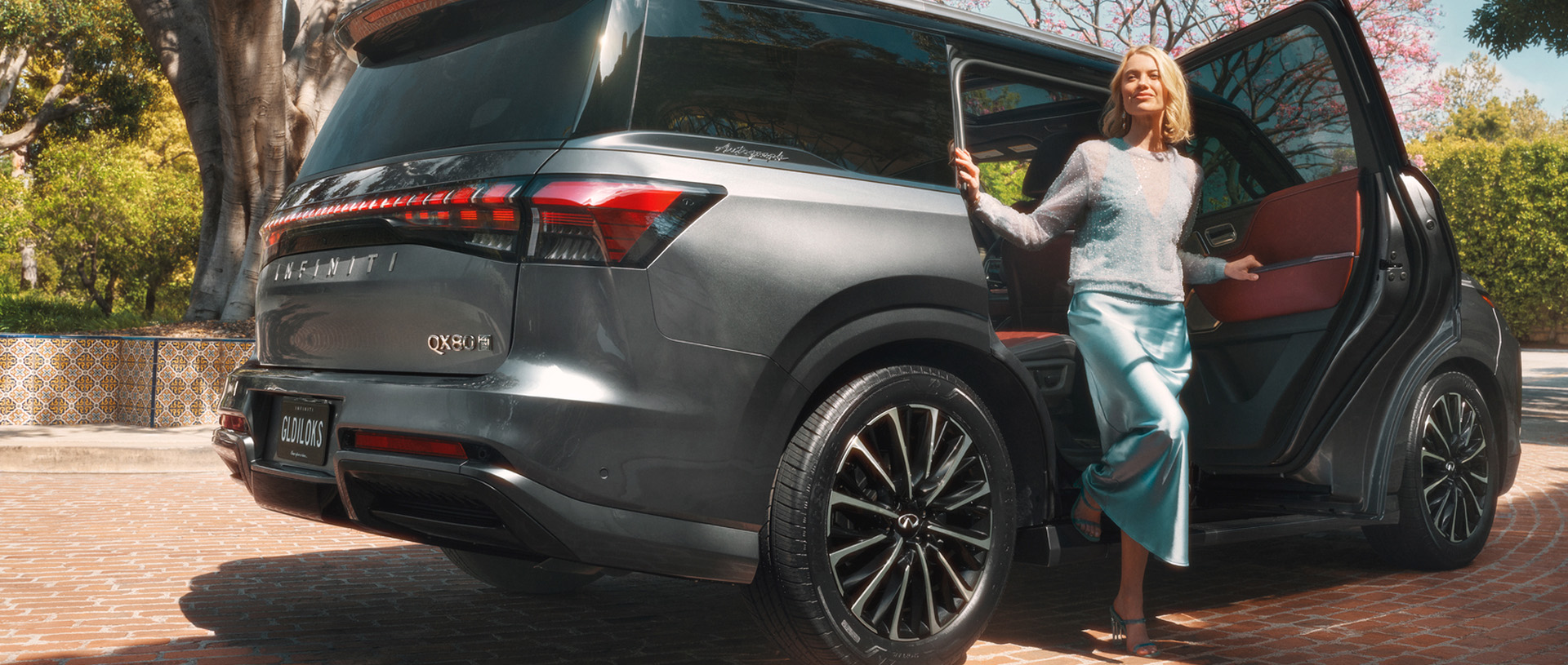 Woman stepping out of INFINITI QX80 rear seat