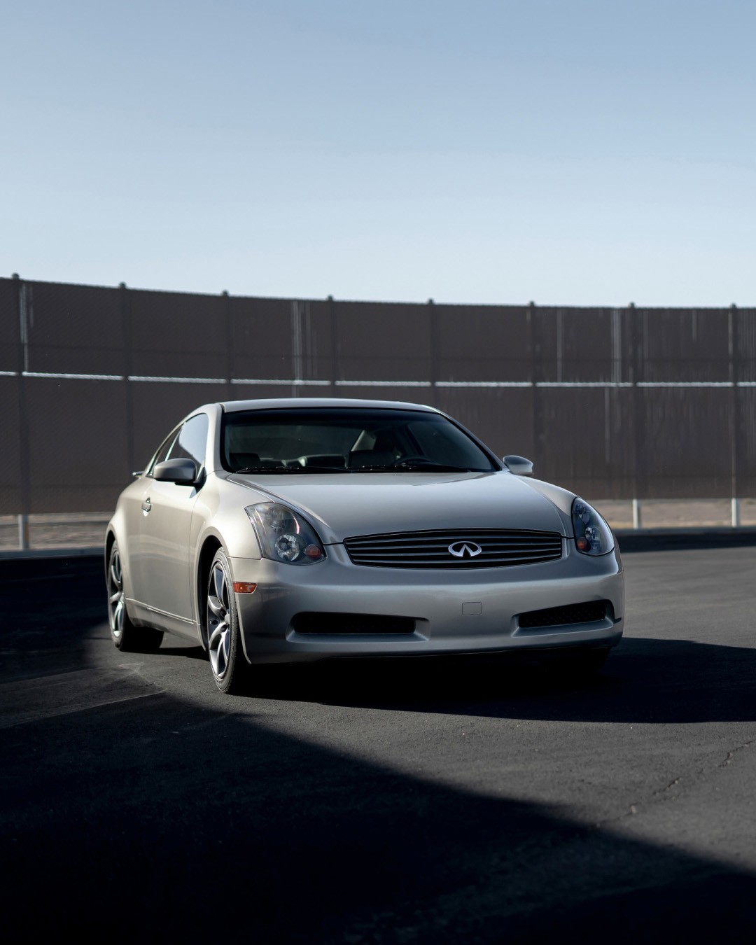 Front view of INFINITI G35 parked in front of fence