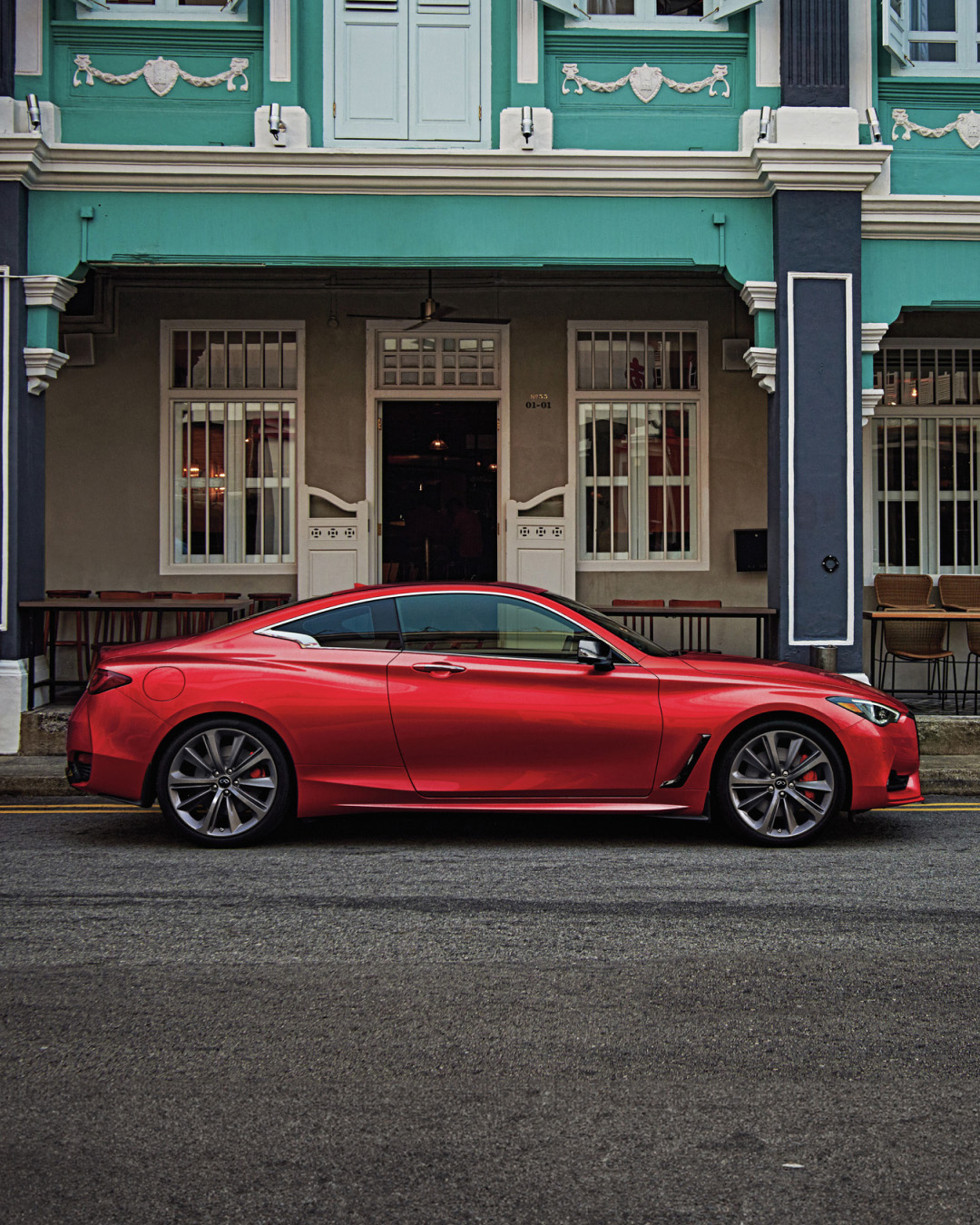 Side view of INFINITI Q60 in red parked in front of house