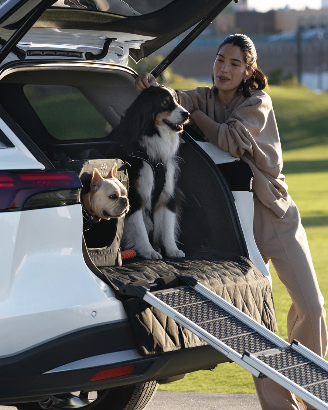 Woman with dogs unloading from INFINITI SUV