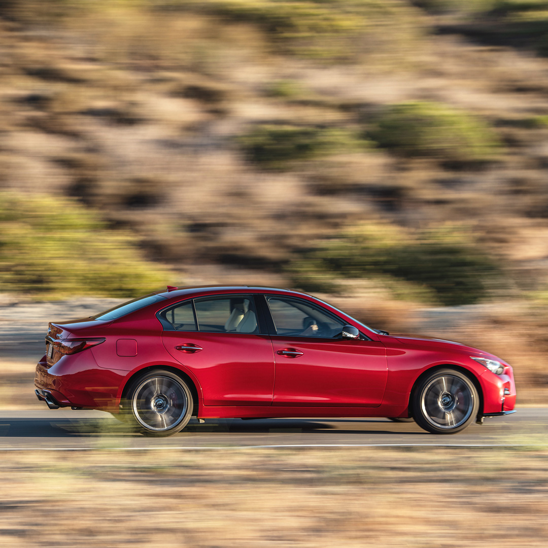 Red Q50 Red Sport edition speeding down highway