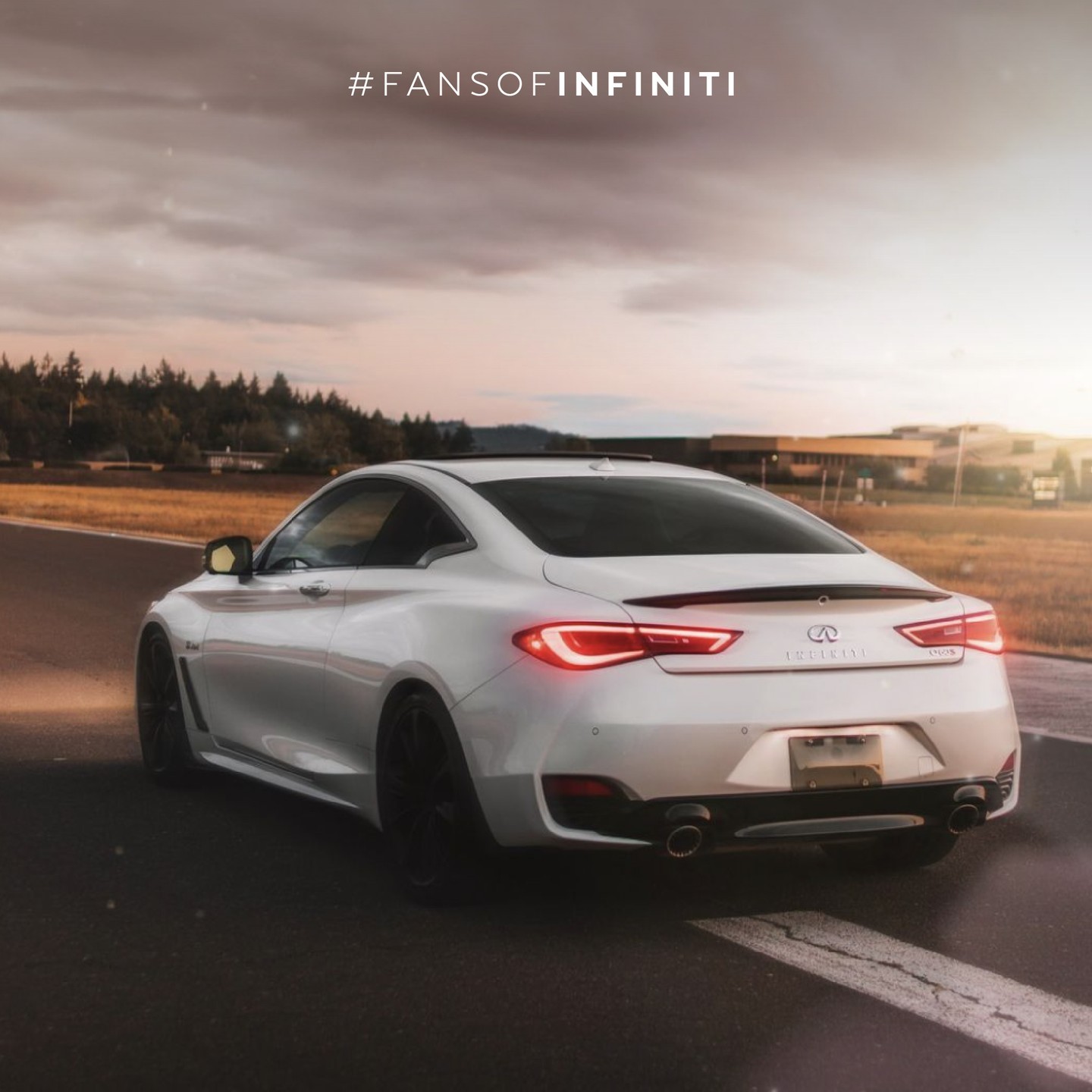 Rear view of INFINITI Q60 in white driving past field