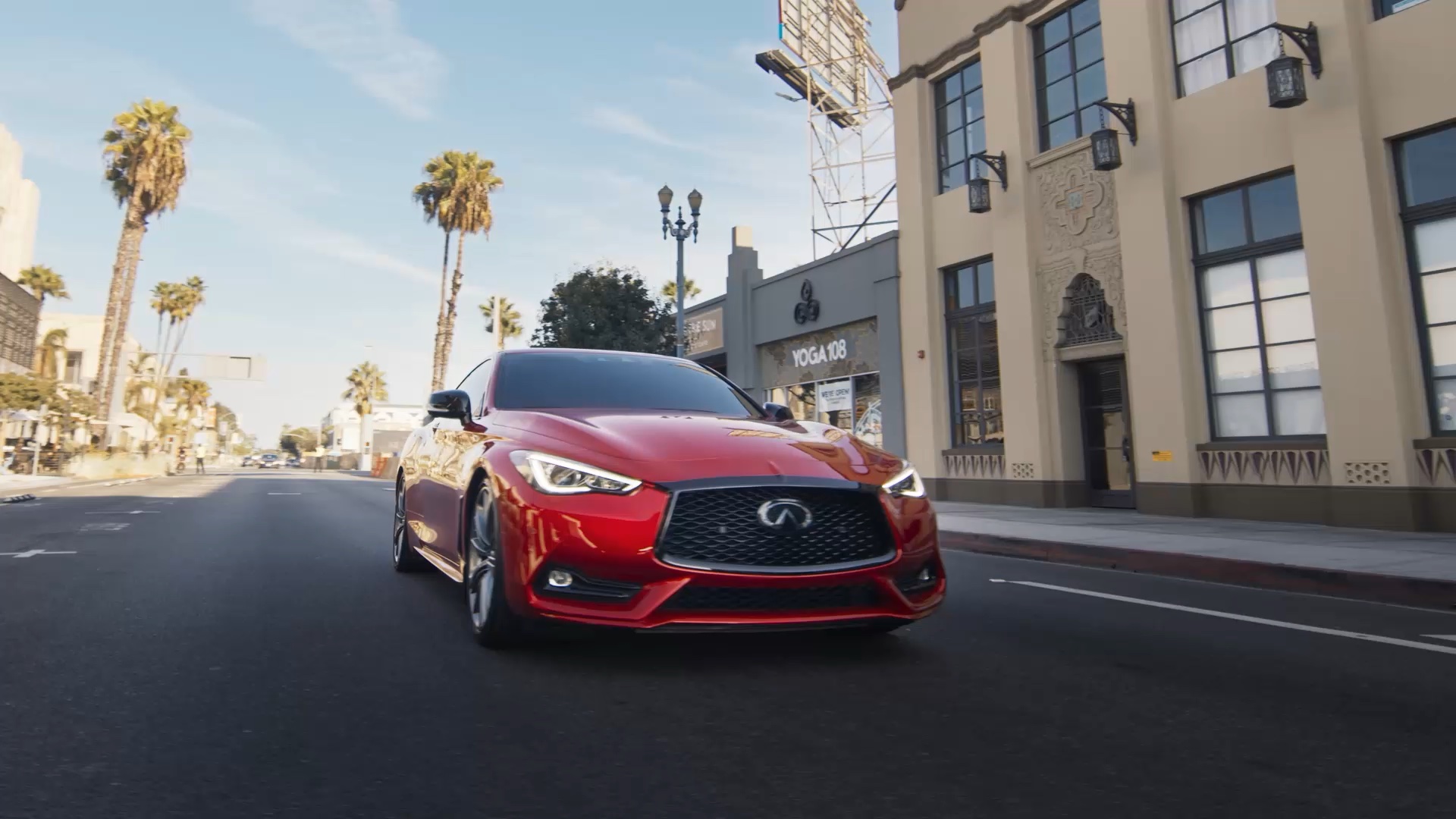 Front view of INFINITI Q60 driving past yoga studio