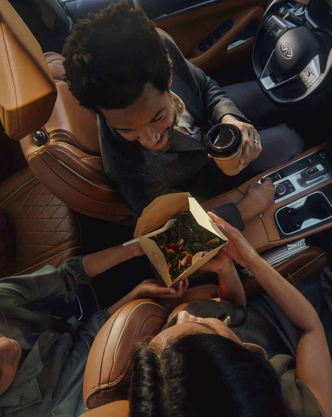 Interior view of INFINITI passengers eating takeout