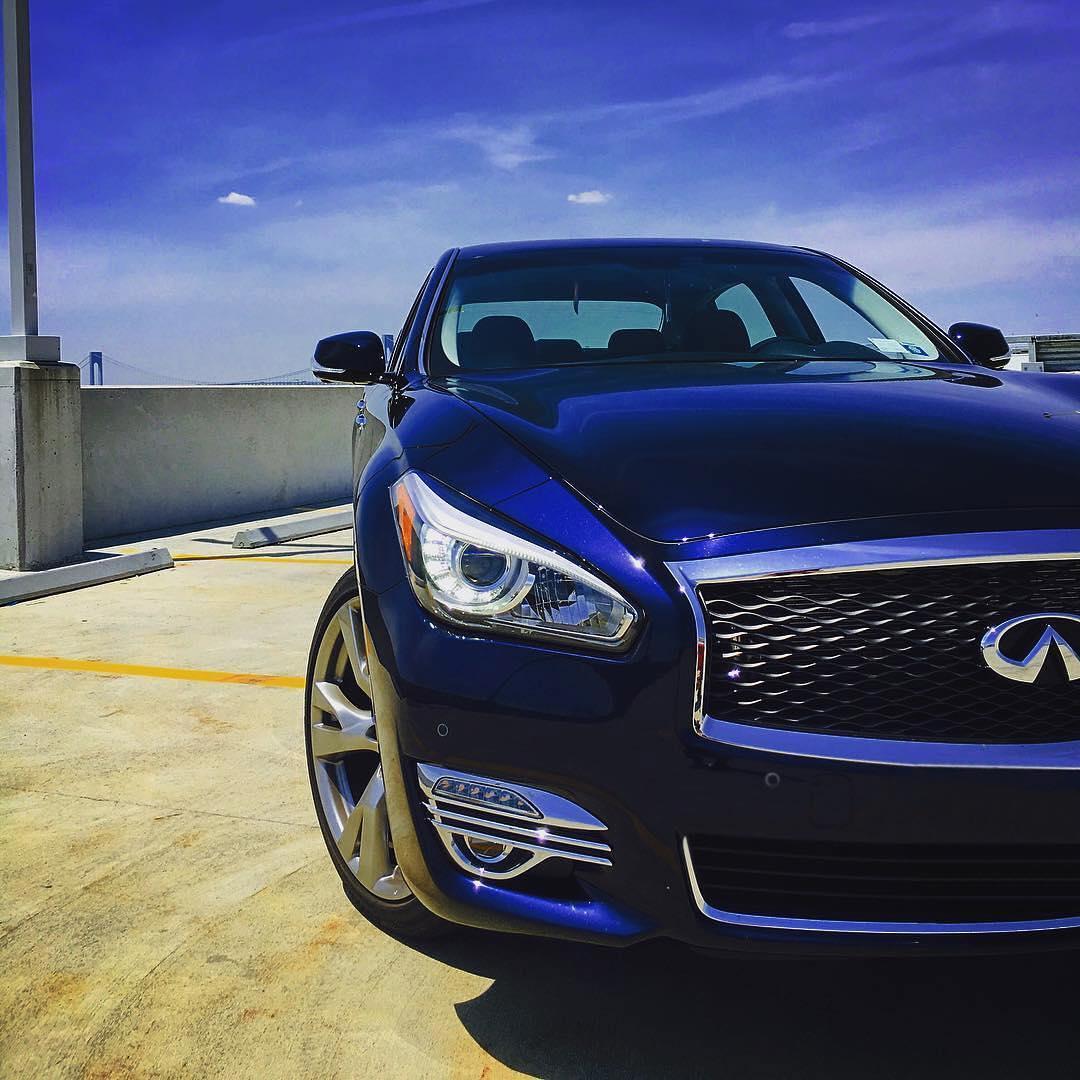 Front view of INFINITI Q70 luxury sedan parked on rooftop parking lot