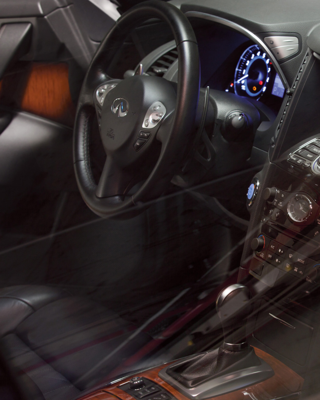 Interior view of INFINITI QX70 Luxury Crossover SUV leather-wrapped steering wheel and shift