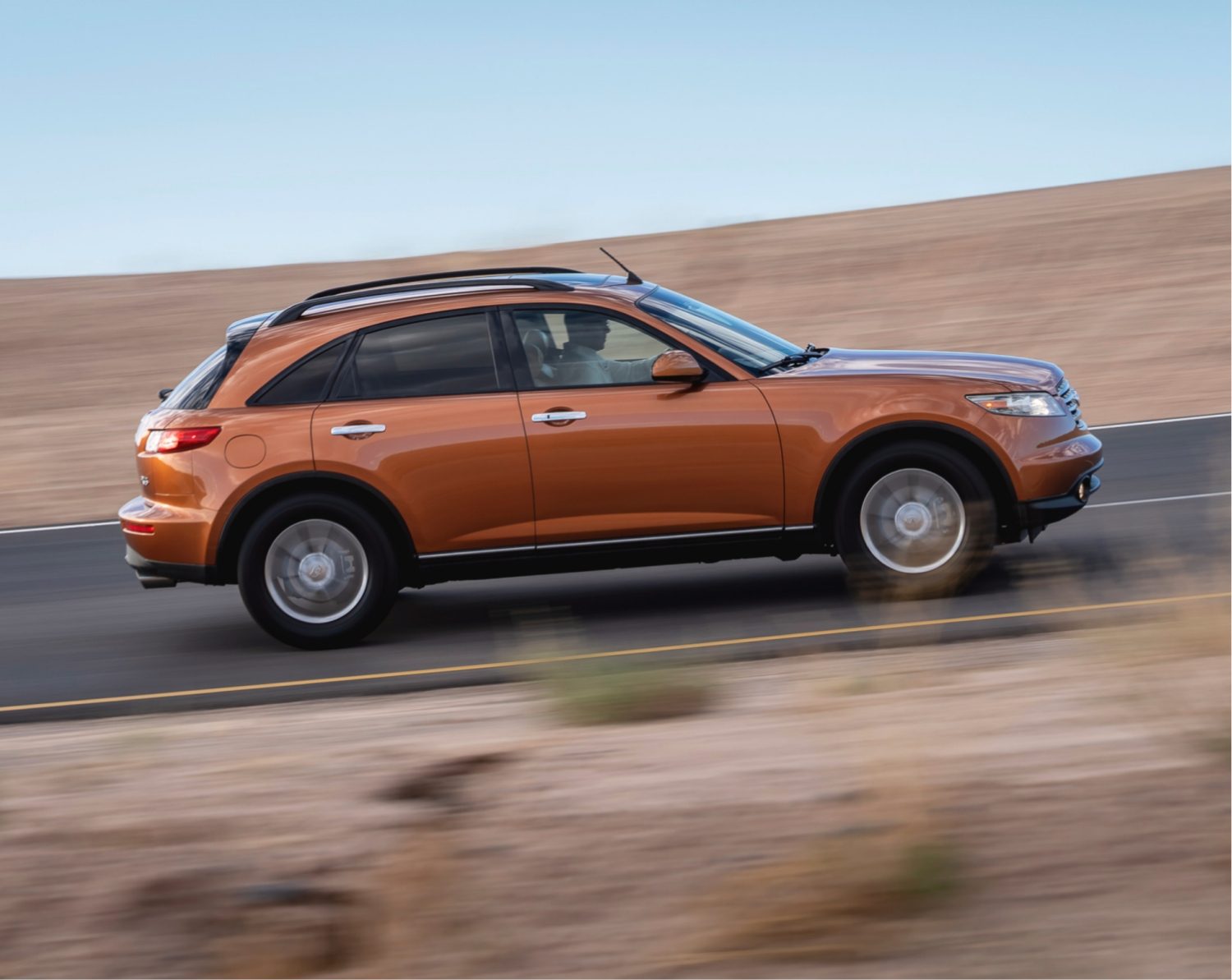 INFINITI QX70 Luxury Crossover SUV in orange driving through plains