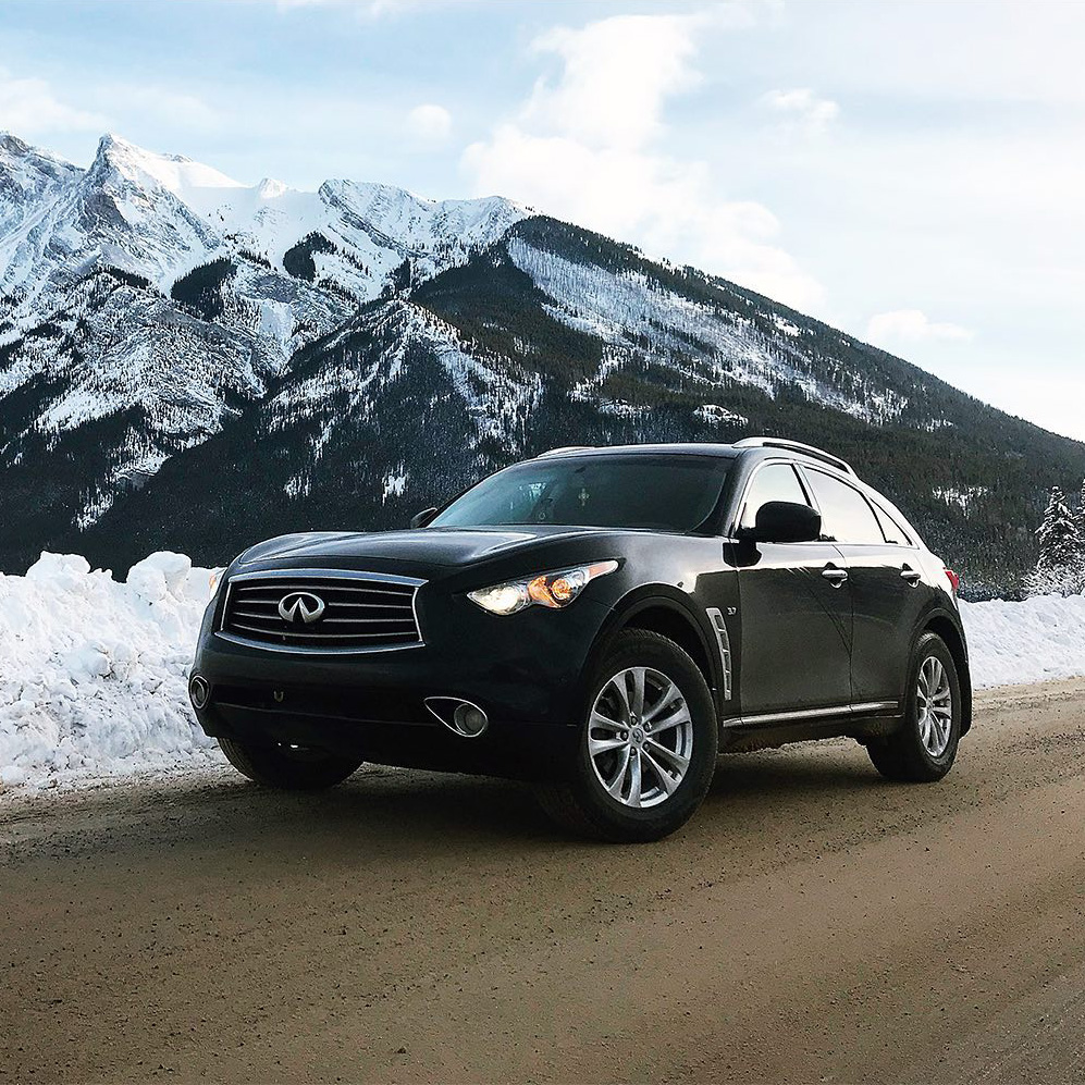 INFINITI QX70 Luxury Crossover SUV parked in front of snowy mountain