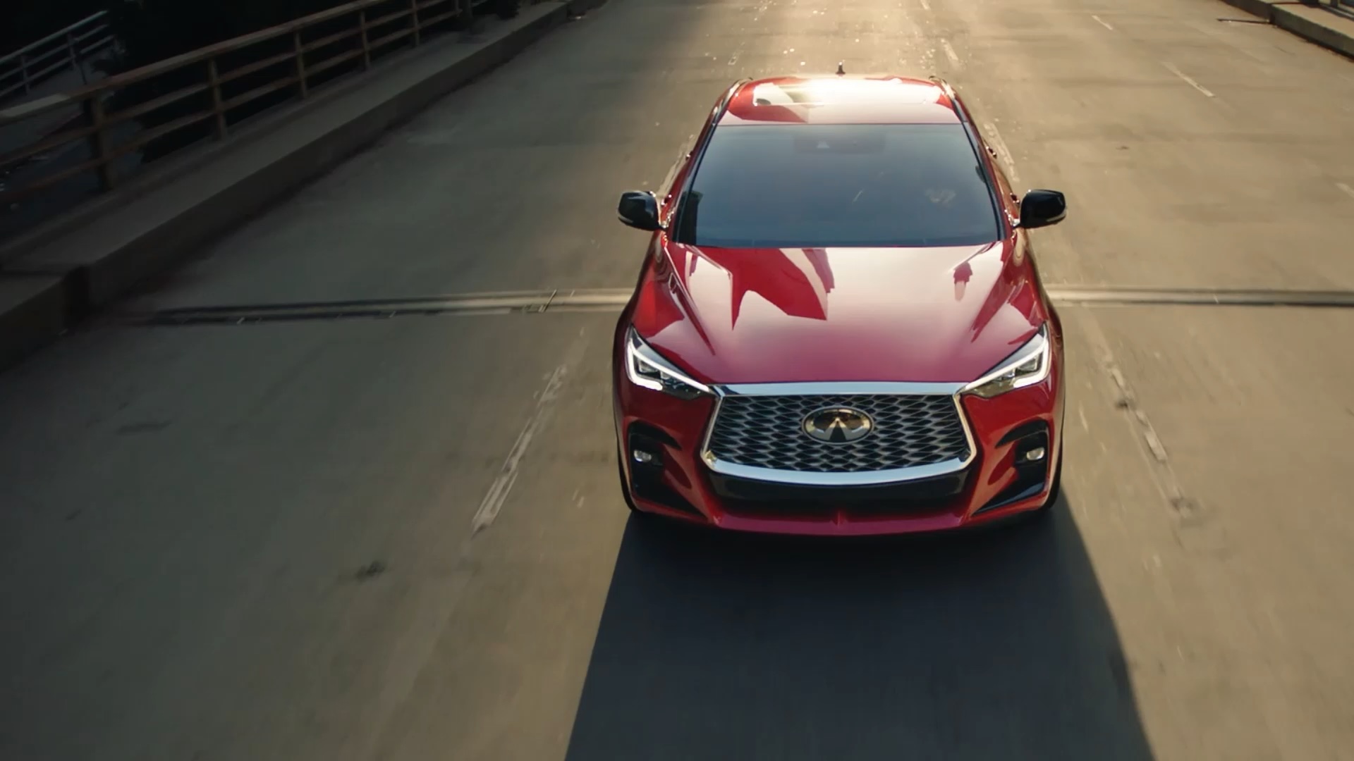 Front view of INFINITI QX55 driving down highway, showcasing engine performance