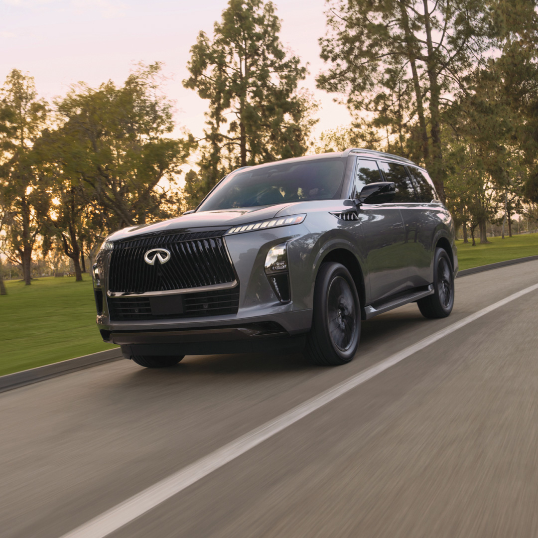 2026 INFINITI QX80 SUV with All-Mode 4WD driving on scenic road