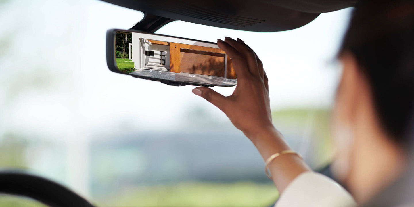 Driver adjusting the 2022 INFINITI rearview mirror.